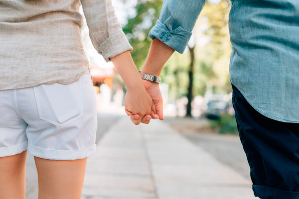 Pequenos gestos de amor: casal passeando de mãos dadas ao ar livre