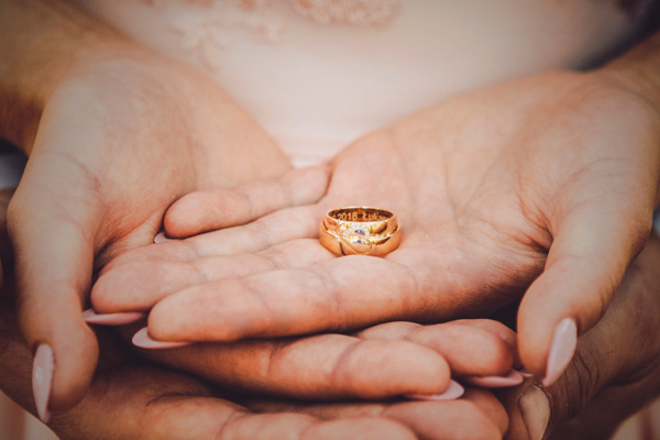 Noivos segurando as alianças de casamento