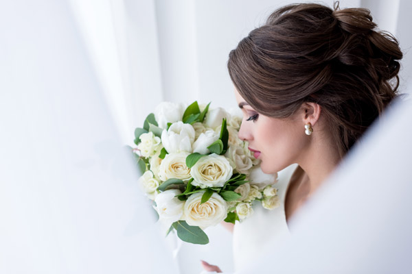 Noiva elegante segurando um lindo buquê de flores brancas