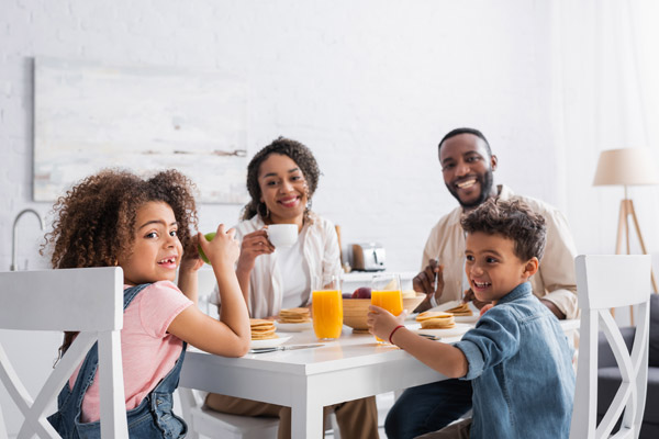 Família com filhos tomando café da manhã em casa