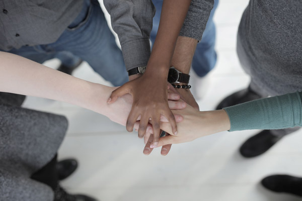 Jovens com as mãos unidas